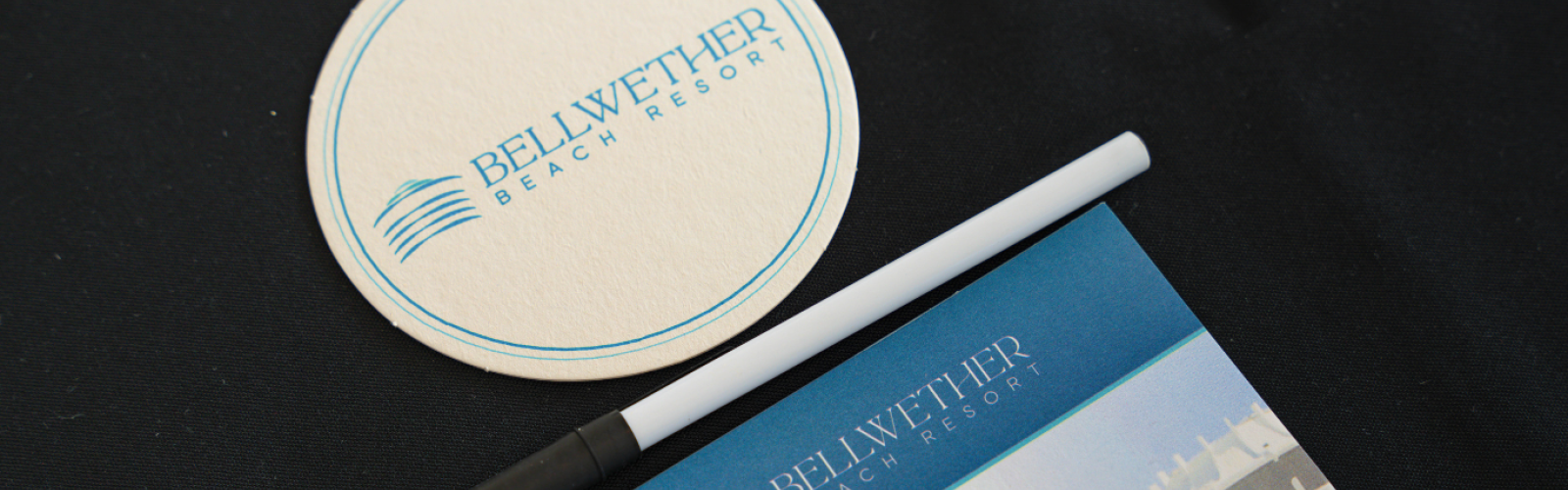 A coaster, pen, and brochure with the 