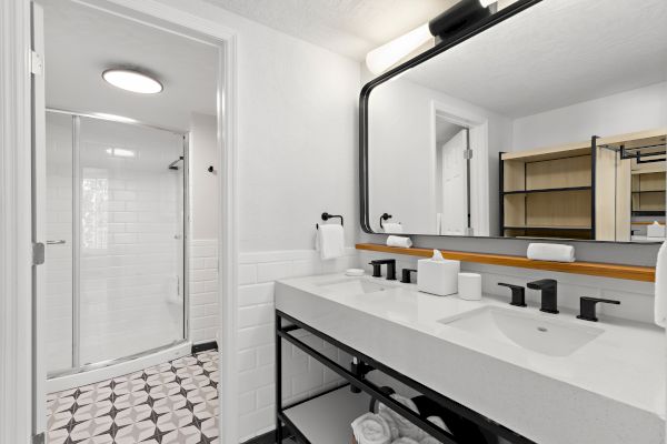 Modern bathroom with a glass shower, mirror, sink, and towels.