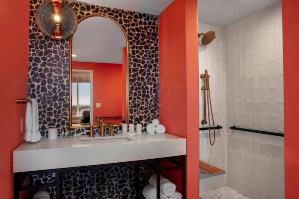 Modern bathroom with a black and white color scheme and a touch of red.
