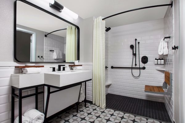 Modern bathroom with a shower, towels, and a mirror.