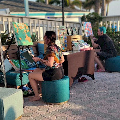 People painting on easels outdoors during daylight.