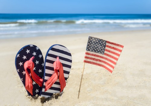 Image of Beach flip flops and American Flag on a sunny gulf Florida beach.