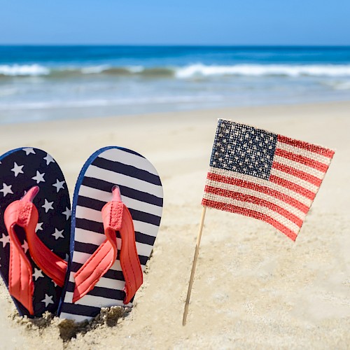 Image of Beach flip flops and American Flag on a sunny gulf Florida beach.