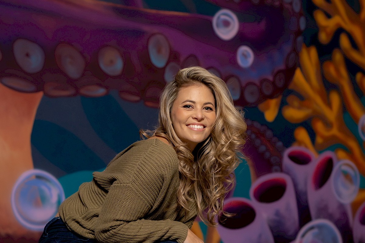 Image of young woman in front of a mural.